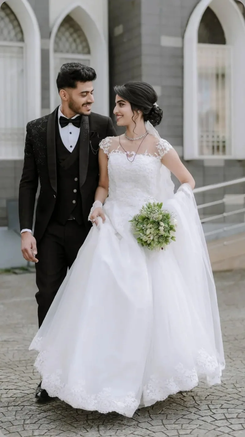 A bride and groom smiling as they walk outside a church