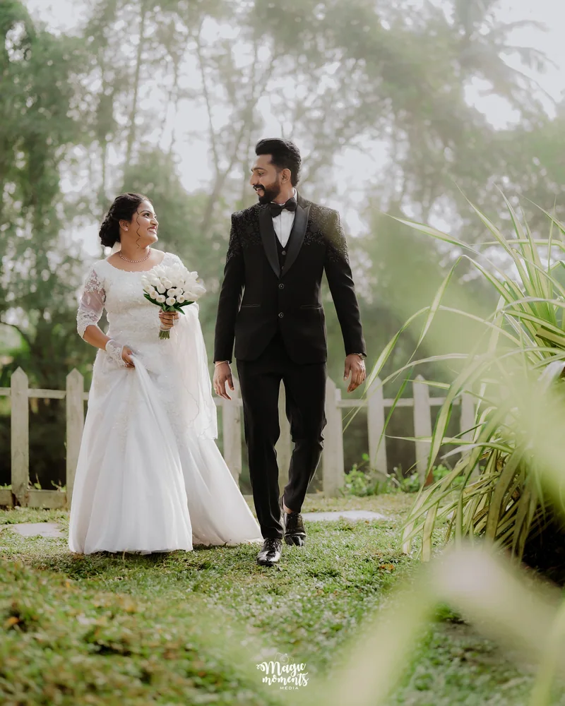 A bride and groom walking hand in hand through a garden