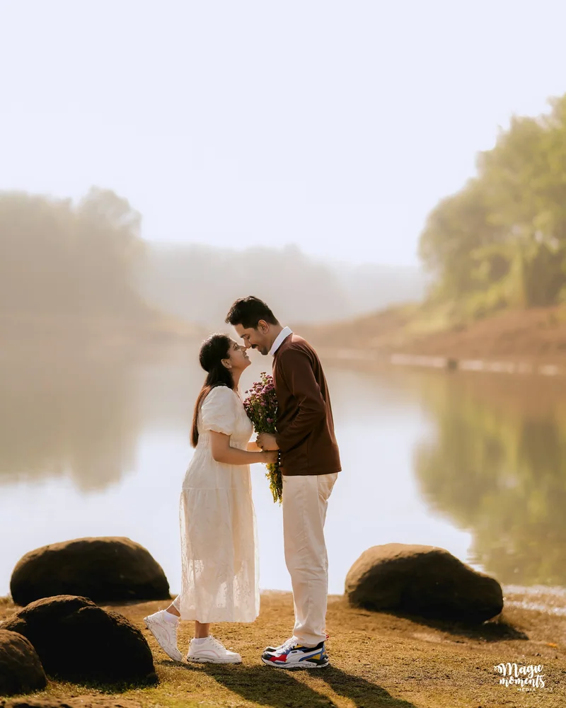 A couple embracing beside a river in warm sunlight